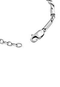 Bracciale in argento con maglie intrecciate e chiusura a moschettone, con una superficie liscia e finitura lucida. Logo del marchio incisa visibile.