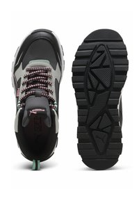 Schwarz-graue Sportschuhe mit strukturiertem Profil, pinken und grauen Schnürsenkeln, weichem Innenfutter und einem Branding-Detail auf der Zunge.