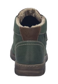 Bottine en cuir vert avec un accent en daim marron, doublée de fourrure douce au col, et légère couture le long des coutures. Elle est dotée d'une semelle en caoutchouc.