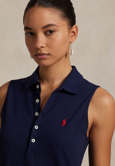 Navy sleeveless polo shirt with a collar, five button placket, and red embroidered logo. Fabric has a smooth, textured appearance.