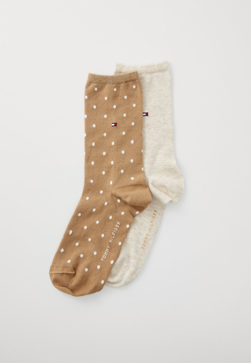 Twee paren sokken: één lichtbruin met witte stippen, de andere beige; van een katoenmix met logodetails bij de boord.
