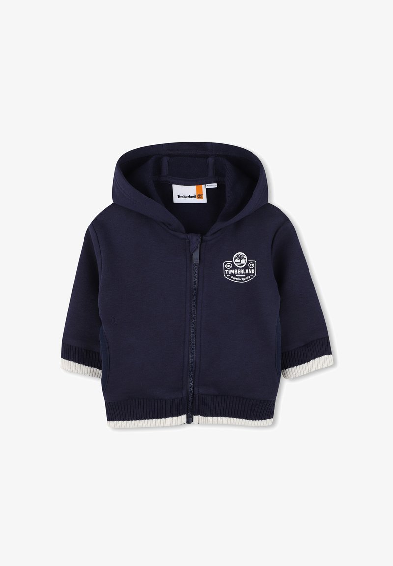Felpa con zip blu navy per bambini, con cappuccio, polsini e fondo a coste bianchi, logo Timberland sul petto e tasche frontali.