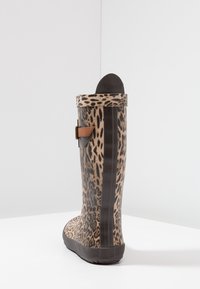 Botte de pluie en caoutchouc à imprimé léopard avec un détail de sangle marron, semelle noire texturée et design à tête arrondie. Le côté présente une bande verticale noire.