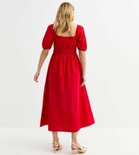 Röd maxiklänning med puffärmar, fyrkantig halsringning, rynkad midja och slät yta. Modellen bär snörsandaler i beige.