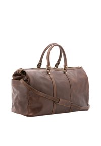 Sac de voyage en cuir marron avec deux poignées, une bandoulière amovible, des finitions en or et des coutures visibles le long des coutures.