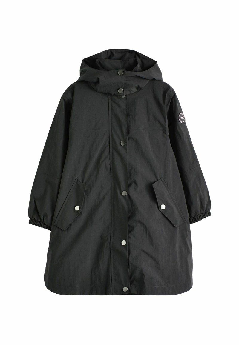 Imperméable long noir avec capuche, boutons-pression sur le devant, deux poches à rabat avec fermeture à pression, poignets élastiques et un patch rond sur la manche gauche.