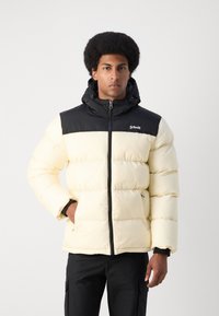 Giacca imbottita di un giallo chiaro con spalle nere, chiusura con zip, cappuccio e tasche laterali. Presenta un design trapuntato e un logo sul petto.