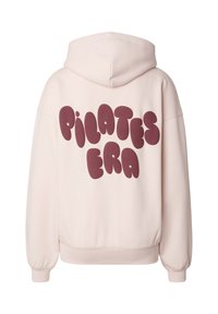 Svetloružová mikina s kapucňou s veľkým bublinovým nápisom "PILATES ERA" v bordovej farbe na chrbte. Má priestrannú kapucňu a rebrované manžety.