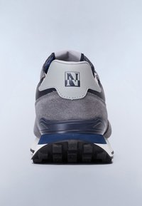 Graue und marineblaue Sneaker von hinten betrachtet, mit strukturiertem Sohlen und einem Logo auf der Fersenlasche vor einem hellen Hintergrund.