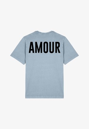 Svijetloplava pamučna majica s crnim natpisom "AMOUR" na leđima. Kratki rukavi i opušteni kroj s okruglim izrezom.
