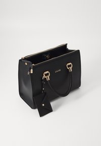 Borsa a tote in pelle nera con hardware dorato, manici doppi, finitura testurizzata, chiusura con zip e un piccolo portacard attaccato.