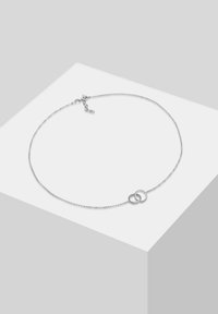 Collana in argento con due anelli circolari intrecciati. Include una chiusura e lunghezza regolabile. Texture liscia e design minimalista.