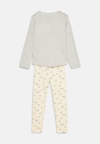 Light grey long-sleeve top paired with cream leggings featuring a small blue floral pattern, laid flat on a white background.