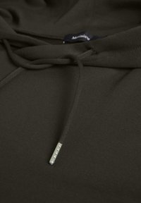 Hanorac de culoare verde măslin închis, cu un material texturat, șnur reglabil cu aglet metalic și un design simplu, minimal.