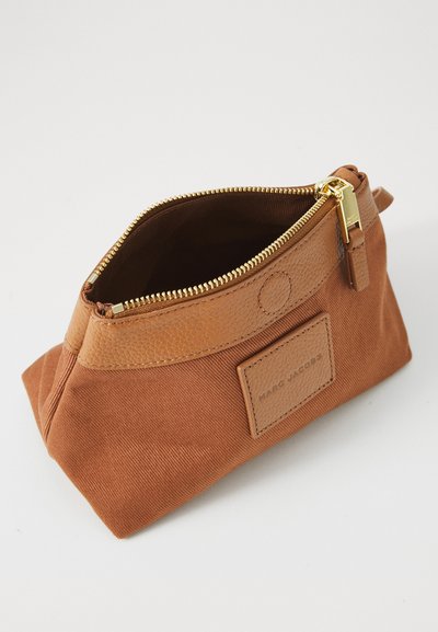 Braune Canvas- und Lederentasche mit goldfarbenem Reißverschluss, rechteckiger Form, strukturiertem Lederakzent und sichtbarem Markenlabel.
