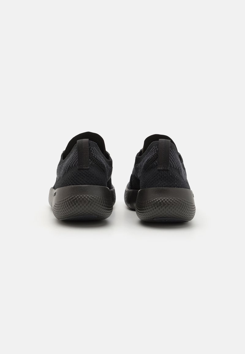 Vista trasera de zapatillas deportivas negras con una parte superior de malla transpirable, cuello acolchado, lengüetas para tirar y suela de goma texturizada para mayor agarre.