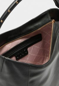Borsa a mano in pelle nera con finitura texturizzata. L'interno presenta un rivestimento in tessuto rosa con un motivo logo ripetuto e una tasca con zip.