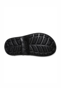 Semelle de chaussure noire présentant un design en caoutchouc texturé avec des motifs de semelle proéminents pour l'adhérence et la traction, surface lisse près du centre.