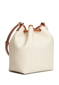 Μπεζ τσάντα τύπου bucket με διακριτικό γεωμετρικό σχέδιο, καφέ δερμάτινη επένδυση και ρυθμιζόμενο λουρί ώμου, παρουσιασμένη σε λευκό φόντο.