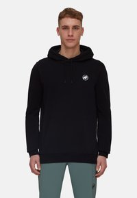 Hoodie noir en tissu doux, avec une poche kangourou et un logo rond sur la poitrine. Équipé d'une capuche à cordon de serrage et de poignets côtelés.