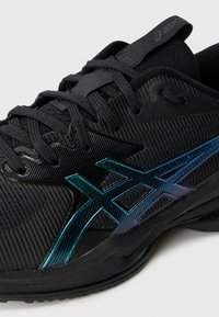 Černá sportovní bota s texturovaným svrškem, síťovaným designem a metalickými akcenty v barvě tyrkysové. Kulatá špička a odolná gumová podrážka.
