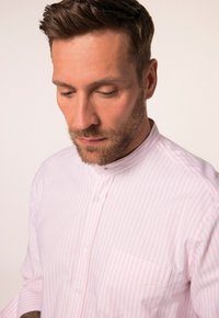 Camicia a righe rosa chiaro e bianca con colletto alla cinese, bottoni frontali e taschino sul petto, realizzata in tessuto morbido per il massimo comfort.