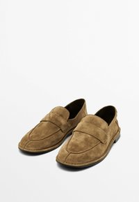 Bruine suede instappers met een brede band over de wreef, ronde neus en gestikte details op de bovenkant en de zool.