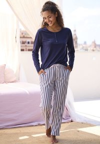 Navy long-sleeve shirt with button placket, paired with white striped pants. Lightweight fabric, casual fit, and drawstring waistband.