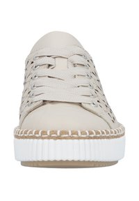 Zapatilla deportiva casual beige con suela blanca gruesa, detalle trenzado encima de la suela y cordones de tela tejida, vista desde el frente.