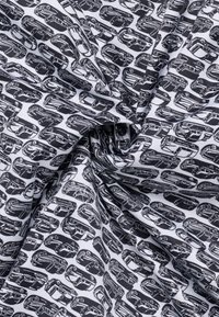 Tessuto bianco e nero con illustrazioni di automobili vintage ripetute, mostrato attorcigliato per mettere in evidenza la texture e i dettagli del motivo.