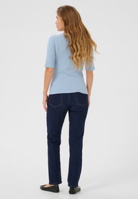 Lichtblauw geribbeld T-shirt met korte mouwen gecombineerd met donkerblauwe slim fit jeans. De jeans hebben een klassiek vijf-pocket ontwerp.