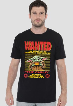 Man wearing black T-shirt with Baby Yoda holding a "Still Hungry" bowl and text "WANTED 'The Child' Cutest Bounty in the Galaxy."