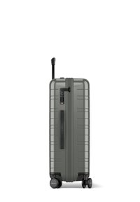 Valise rigide grise avec une finition texturée, une poignée extensible, des roues noires et un cadenas à combinaison sur le côté pour plus de sécurité.