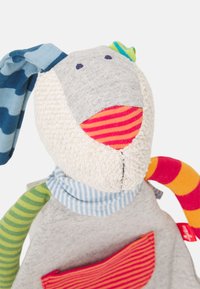 Gevulde speelgoedhond met een grijze, gestructureerde lichaamsvorm, multicolore gestreepte ledematen en een zachte, fleece-achtige kop. Heeft een mond met rode en witte strepen.