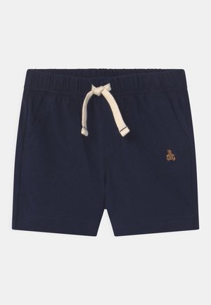 Donkerblauwe peutershort met elastische tailleband, crèmekleurige trekkoordsluiting, zijzakken en een kleine geborduurde teddybeer op het rechterbeen.
