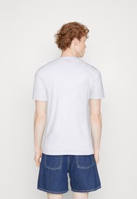 Hvid t-shirt med korte ærmer lavet af bomuldsstof, rund halsudskæring, tætsiddende stil, med en glat tekstur og uden synlige mønstre.