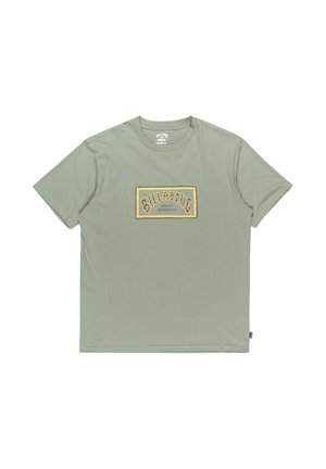 Camiseta de algodón verde claro con un estampado gráfico rectangular amarillo que presenta "BILLABONG" y "AUSTRALIA" en una fuente estilizada. Mangas cortas.