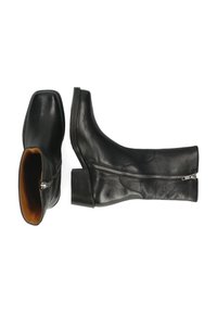 Czarne skórzane botki za kostkę z kwadratowym noskiem, bocznym zamkiem błyskawicznym i niskim blokowym obcasem. Wnętrze wyłożone jest kontrastową brązową podszewką.