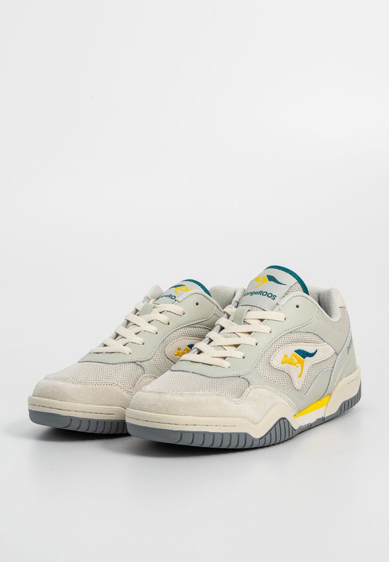 Jasnoszare sneakersy wykonane z zamszu i siateczki. Mają niebieskie i żółte logo, białe sznurówki oraz gumową podeszwę z szarym wzorem.