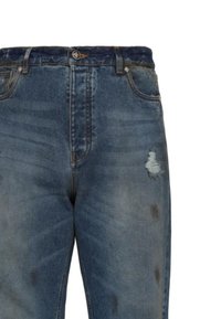 Jeans in denim blu con vita alta, caratterizzati da uno strappo sfilacciato sulla coscia destra, cinque tasche e chiusura con bottone classico.