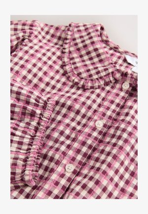 Baumwollbluse mit kariertem Muster in Bordeauxrot und Creme, mit einem gerafften Kragen und fünf Knöpfen vorne. Strukturierter Stoff.