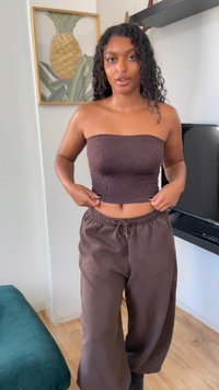 Top brown fără bretele cu un model texturat, purtat cu pantaloni lejerați maro, prevăzuți cu un tiv elastic și detalii cu șnur.