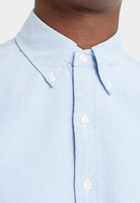 Ljusblå skjorta med knapp-up i texturerad tyg, med klassisk krage, vita knappar och en smal passform.