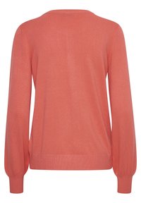 Pull en corail avec un col rond et de longues manches bouffantes. Il présente une texture lisse ainsi que des poignets et un ourlet côtelés.
