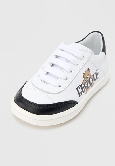 Λευκό αθλητικό παπούτσι με μαύρο δερμάτινο δάχτυλο και φτέρνα. Διαθέτει λευκά κορδόνια και τυπωμένο λογότυπο αρκούδας στην πλευρά. Υφή από καουτσούκ στη σόλα.