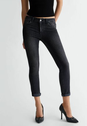 Jeans skinny neri con vita media, caratterizzati da dettagli in strass lungo il davanti e risvolti alle caviglie.
