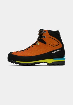 Botte de randonnée orange et noire avec une tige à texture, un capuchon de protection renforcé, un système de laçage et une semelle intermédiaire et semelle extérieure multicolores.