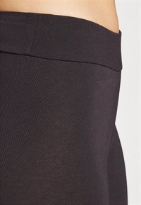 Svarta stretch leggings med en slät yta och en bred midja, som har en tajt passform och sömlös konstruktion.