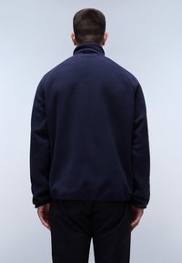 Marineblaues Fleece-Jackett mit hohem Kragen und langen Ärmeln. Schlichte Gestaltung, weiche Textur und keine sichtbaren Beschläge oder Muster.