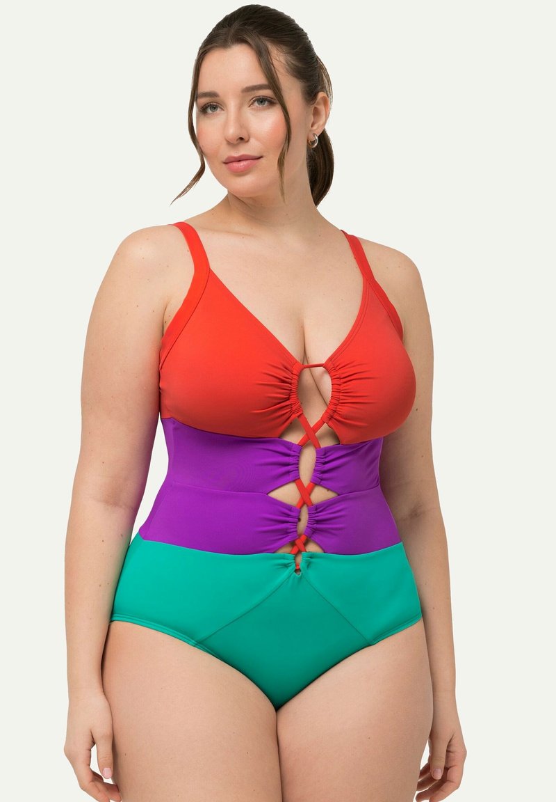 Maillot de bain une pièce avec des sections rouges, violettes et vertes. Comprend des découpes et des fronces au niveau de la poitrine et de la taille. Tissu lisse.